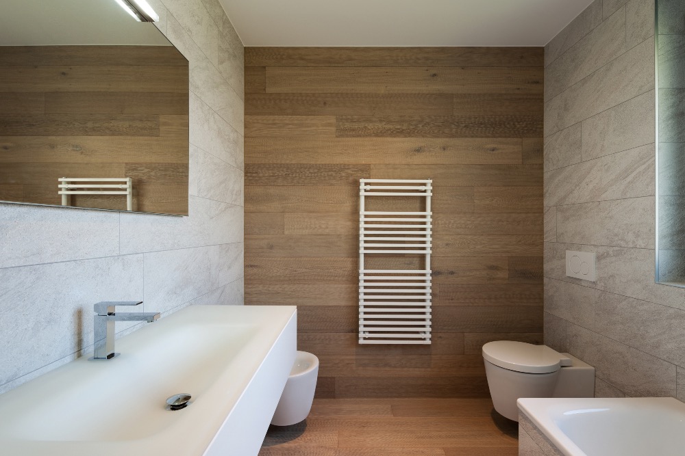 White towel rail on wood effect tiled wall in luxury bathroom
