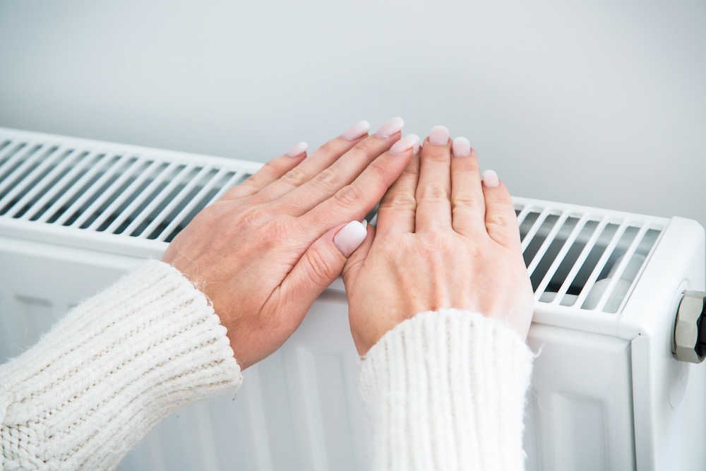 Person warming hands up using a radiator
