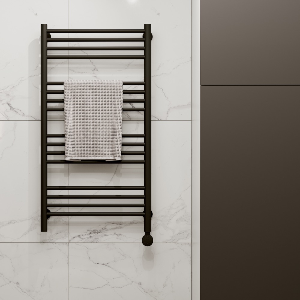 Black towel rail on white tiled wall with white towel hanging off