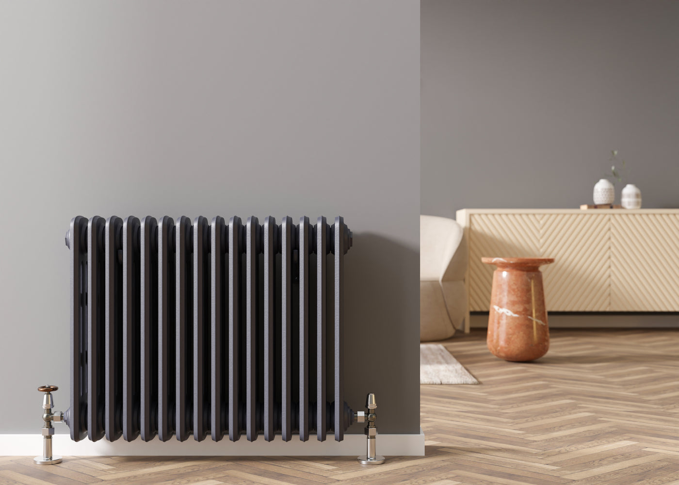 Black column radiator with chrome valves in a contemporary living room with herringbone wood flooring.