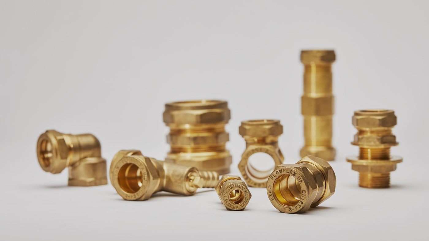 Assorted brass compression pipe fittings displayed on a plain white background.
