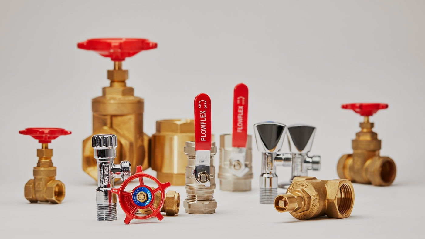 Assorted brass and chrome plumbing valves, including gate valves, ball valves and radiator valves, on a white background.