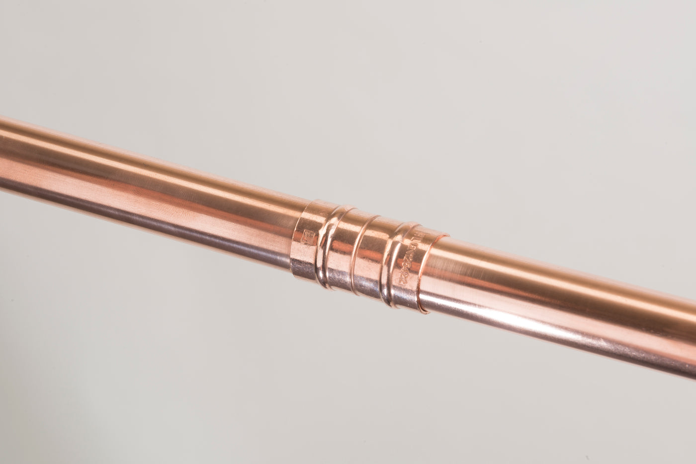 Close-up of a completed solder-ring fitting joining two copper pipes.