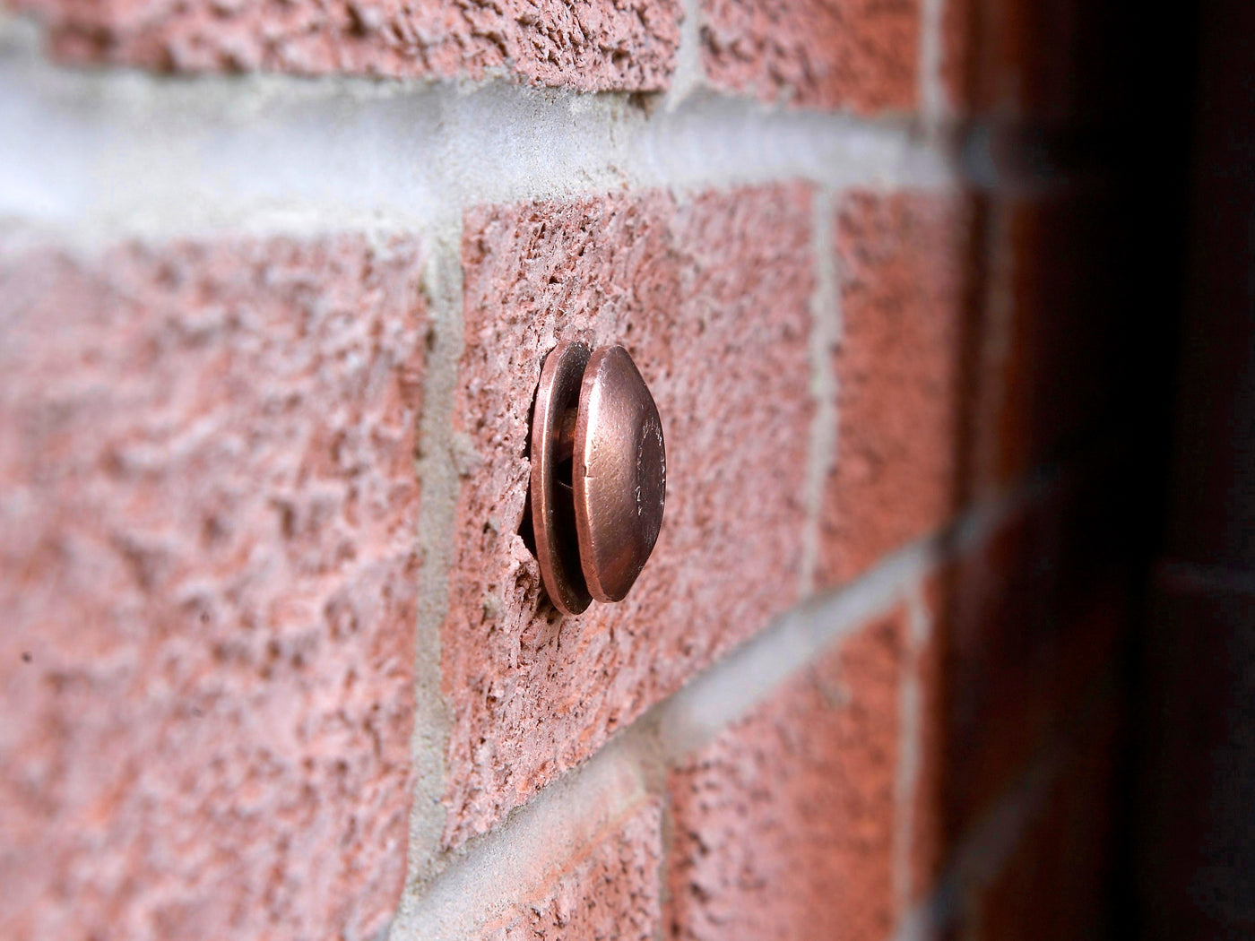 Close-up of a Flowflex Pipe Cowl fitted to an exterior brick wall.