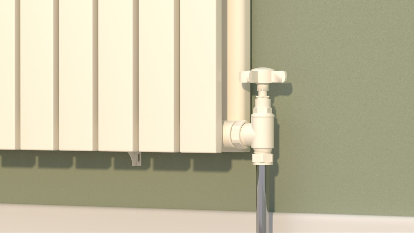 White angled manual valve connecting a floor pipe to a white panel radiator against a green wall.