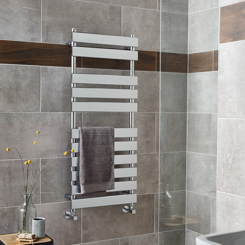 PlumbHQ chrome towel rail on wall in a bathroom with brown tiles