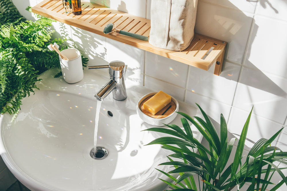 Chrome tap in natural themed bathroom surrounded by foliage